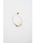 white beaded bracelet with gold pave heart shaped beads on a light gray background