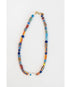 colorful painted stripe beaded necklace with a white fish charm on a light grey background
