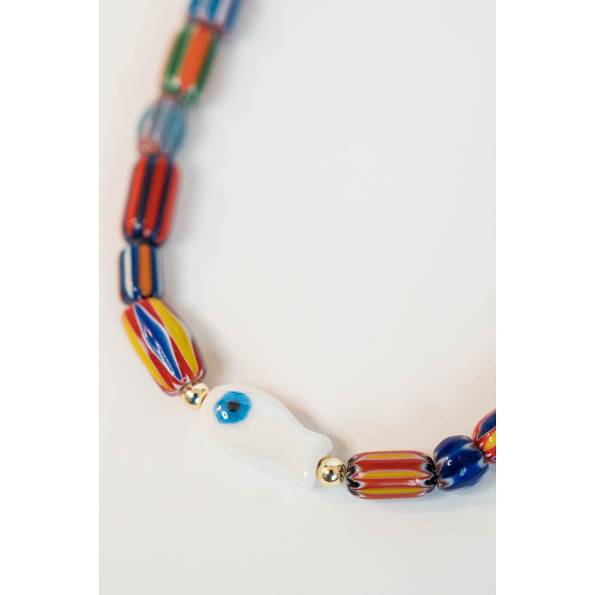 Colorful beaded necklace with a white fish pendant on a light gray background