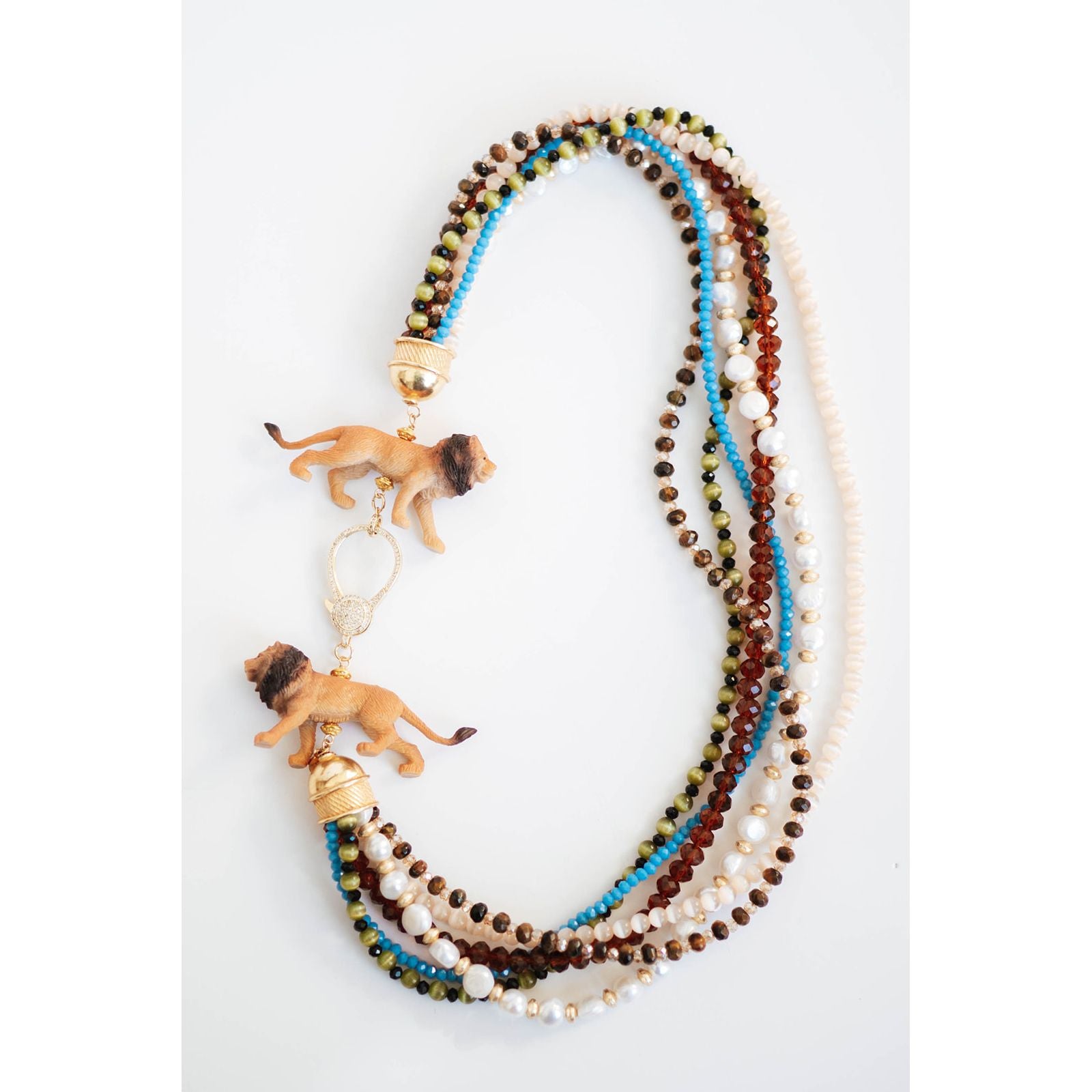 statement necklace with multiple strands of multicolored beads  and lion figurines with a gold pave clasp on a white background