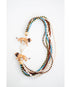 statement necklace with multiple strands of multicolored beads  and lion figurines with a gold pave clasp on a white background