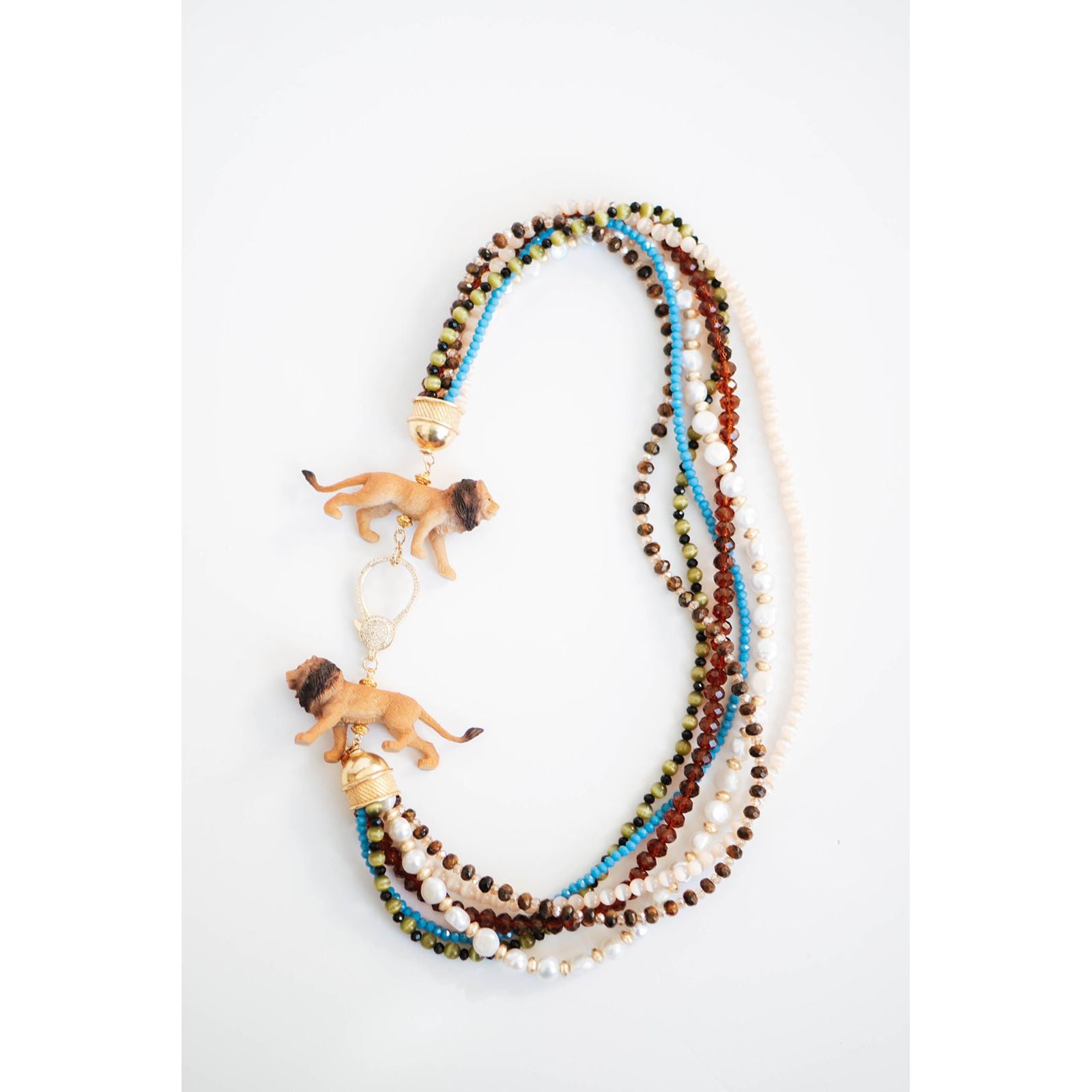 statement necklace with multiple strands of multicolored beads  and lion figurines with a gold pave clasp on a white background