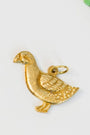 vintage goose-shaped gold/brass charm on a light background