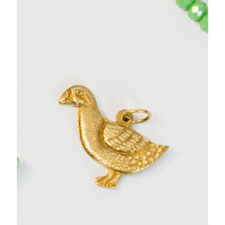 vintage goose-shaped gold/brass charm on a light background