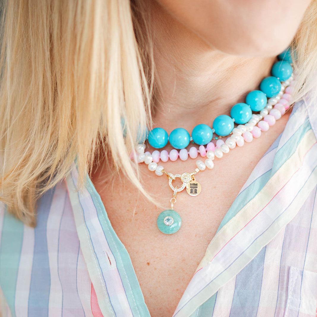 Close-up of a person wearing a colorful beaded necklace with a striped shirt.