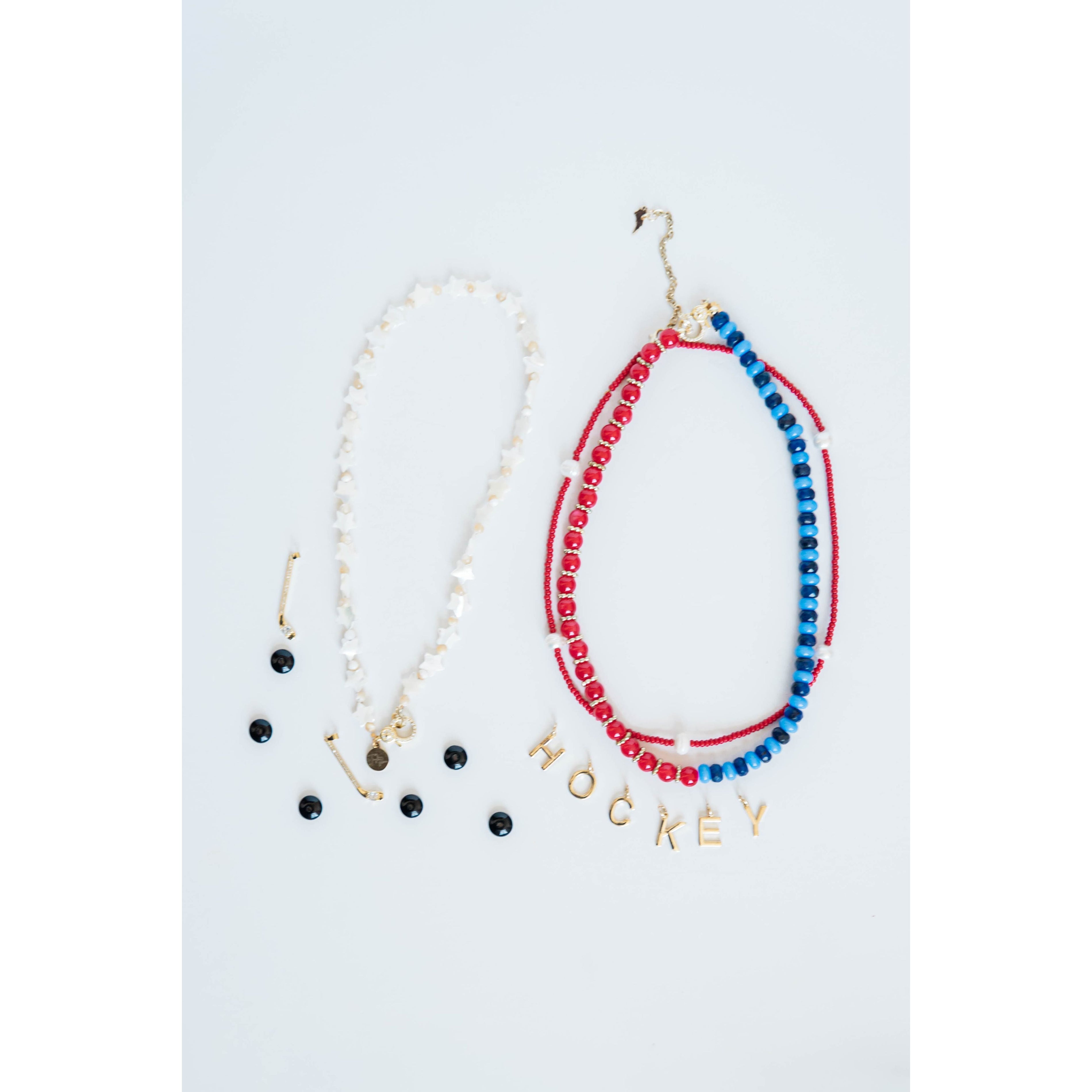 white star Necklace with 'HOCKEY' spelled out in charms and red white and blue beaded strands on a light gray background