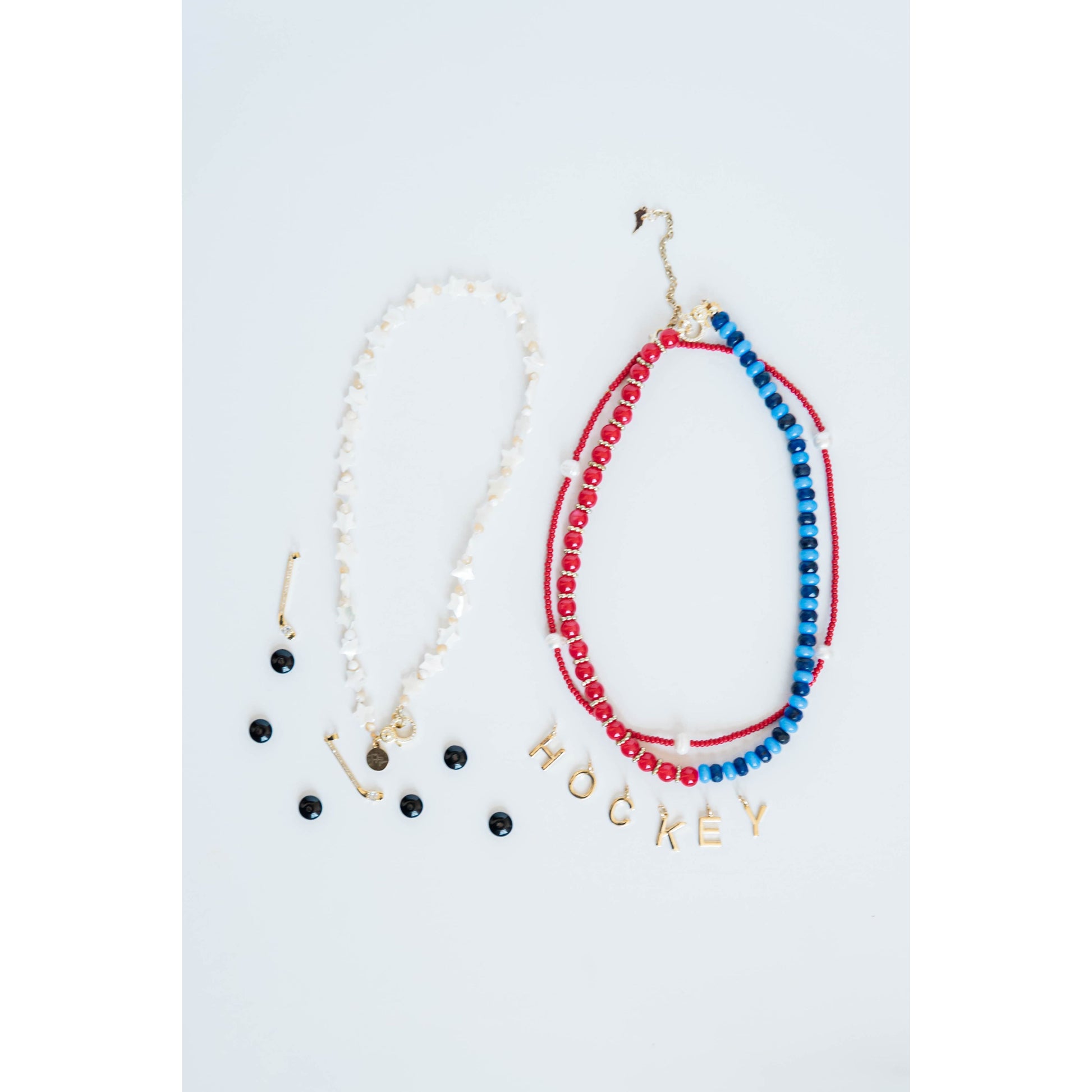 white star Necklace with 'HOCKEY' spelled out in charms and red white and blue beaded strands on a light gray background