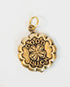 gold and brass charm with "good luck" engraved and a 4 leaf clover in the center on a light background