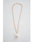 thick gold chain necklace with an oversized pearl pendant on a light grey background