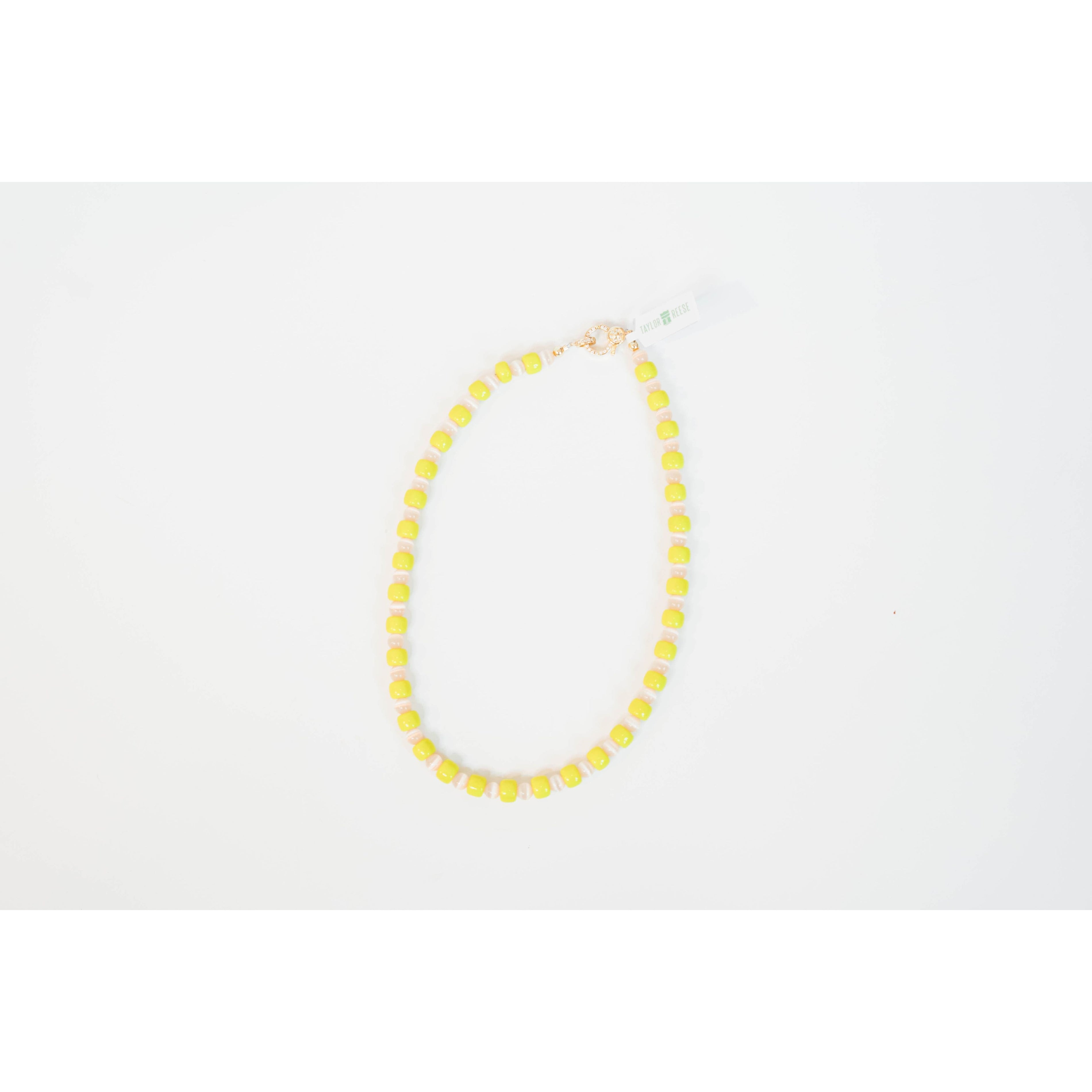 neon yellow beaded necklace with glass roller beads in between and a gold pave clasp