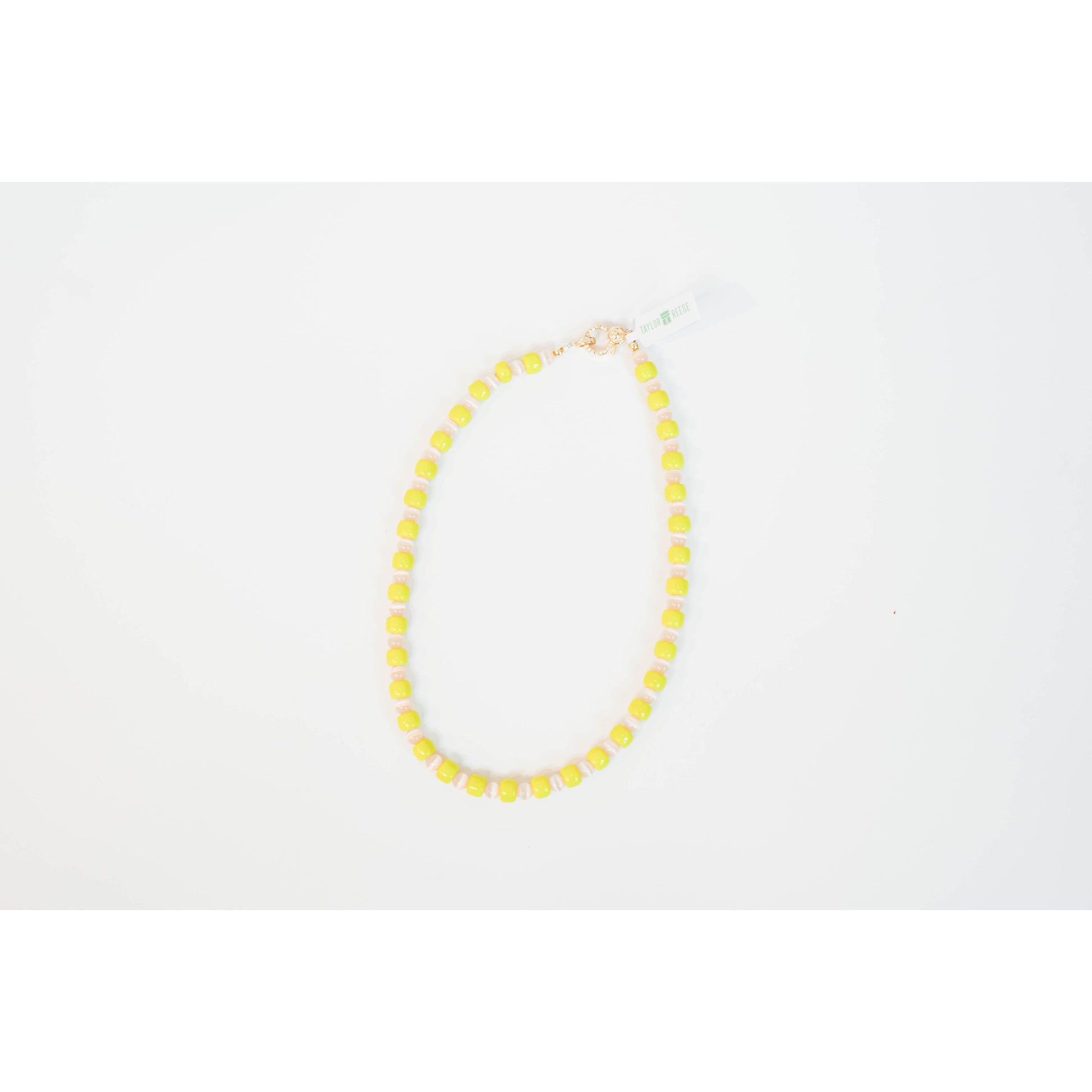 neon yellow beaded necklace with glass roller beads in between and a gold pave clasp