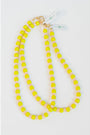 two neon yellow beaded necklaces with glass roller beads in between and a gold pave clasp