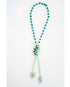 Turquoise beaded necklace with a floral pendant on a white background