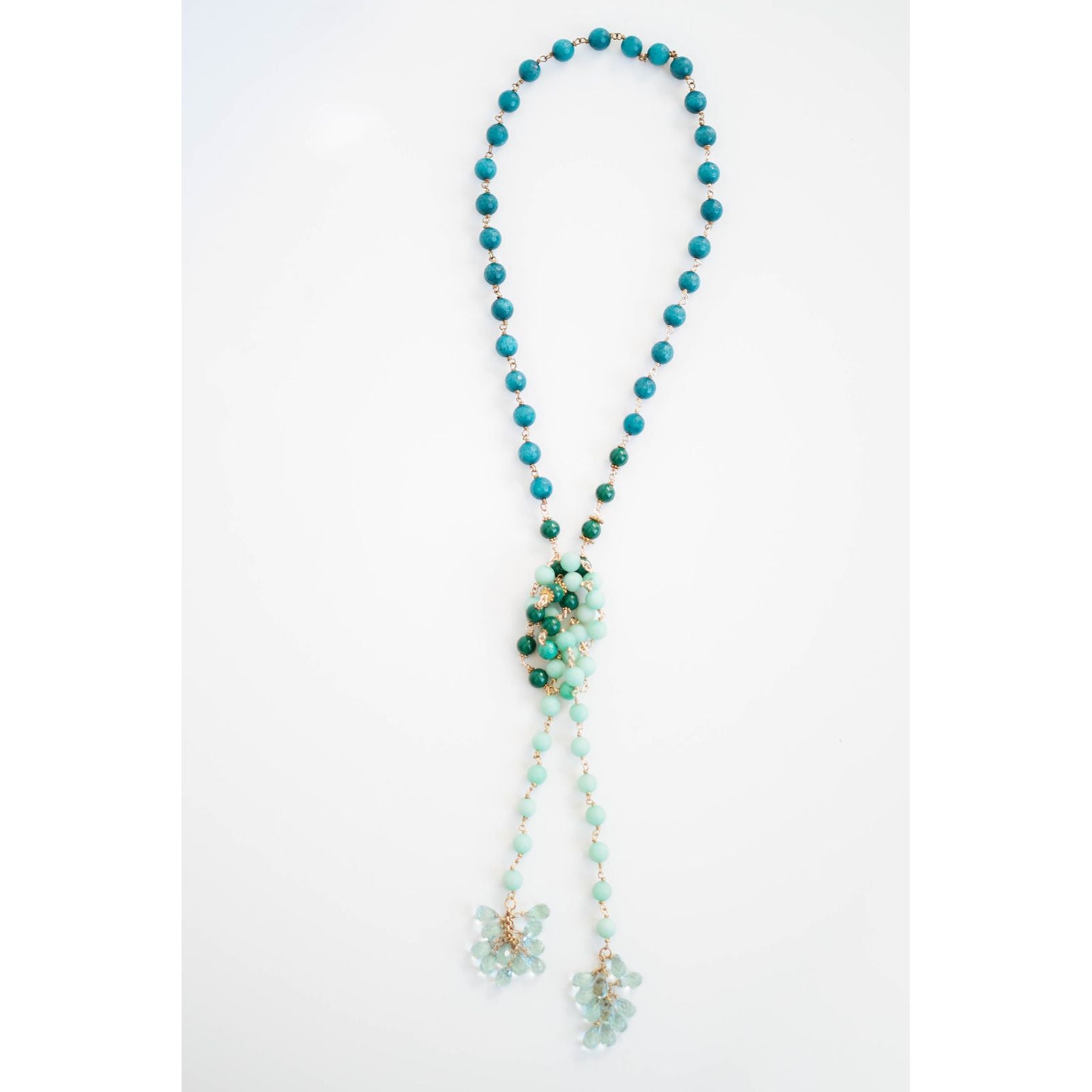 Turquoise beaded necklace with a floral pendant on a white background