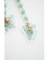 Necklace with light blue beads and gold accents on a white background