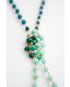 Necklace with green and gold beads on a white background