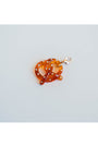 light brown acrylic pretzel charm with rhinestone detailing on a light grey background