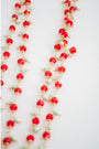 Necklace with red crystal, mint green, and gold beads on a white background
