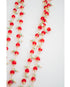 Necklace with red crystal, mint green, and gold beads on a white background
