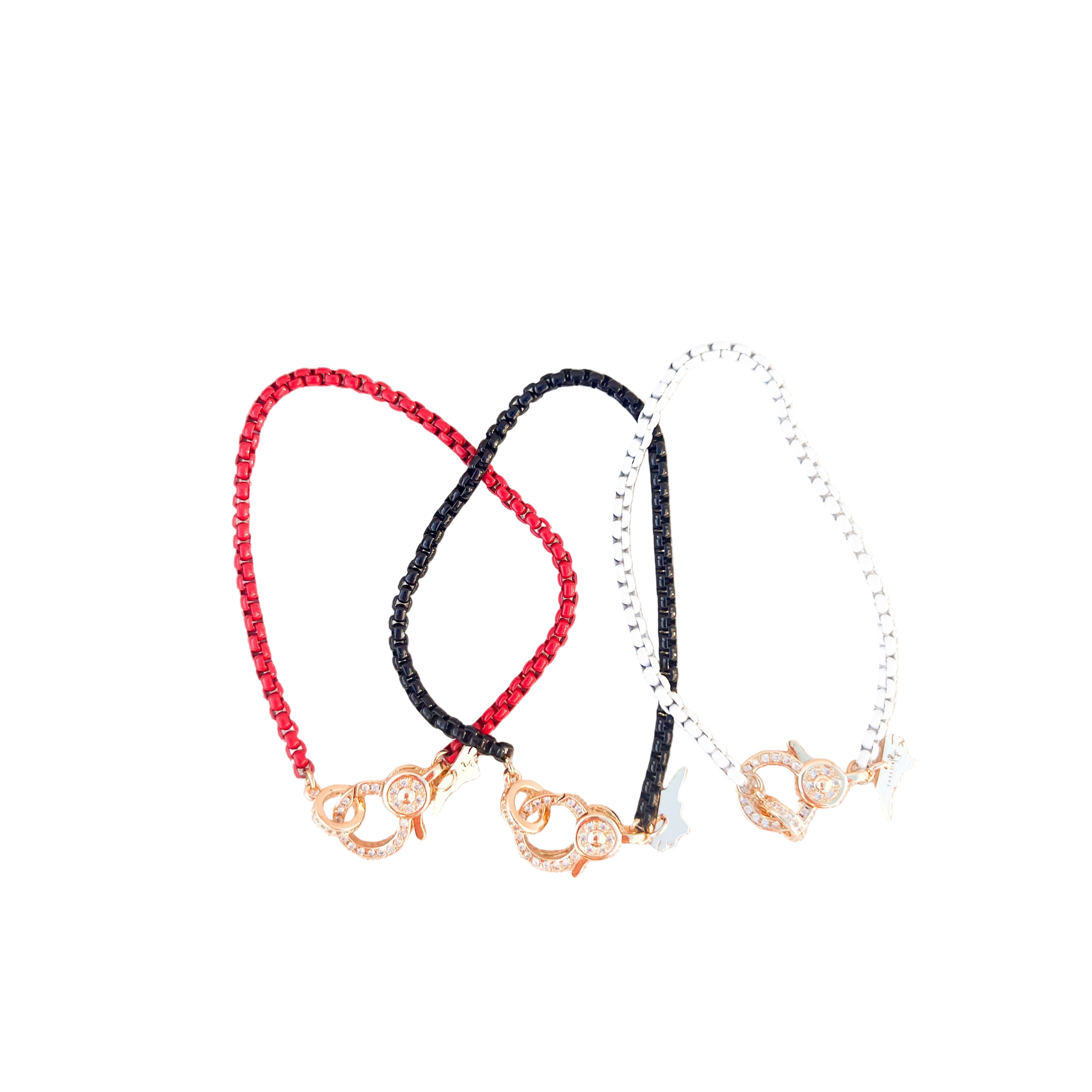 Three enamel chain bracelets in red, black, and white with gold pave lever clasp on a white background
