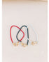 set of 3 overlapping box chain bracelets in red, black, and white with gold pave lever clasps on a light background