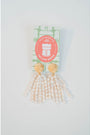 Gold and pearl tassel earrings on a white background with a visible brand label.