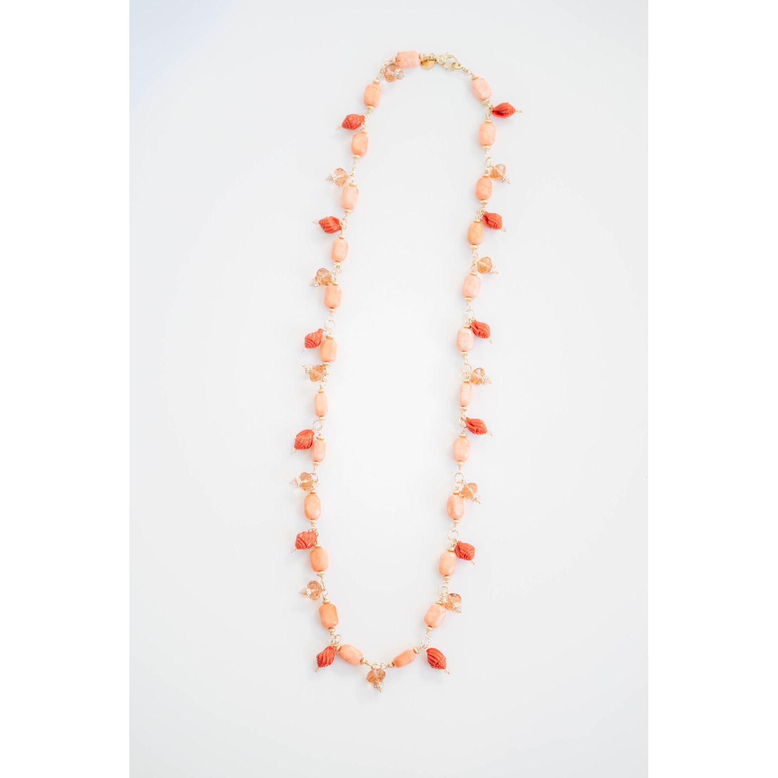 Necklace with orange and peach seashell beads on a white background