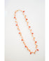 Faceted crystal beads and conch shell shaped beads are dangling off a long orange beaded chain necklace