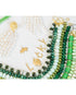Collection of gold charms that spell out "LUCKY" and  green and white beaded necklaces and white pearl tassel earrings on a white background