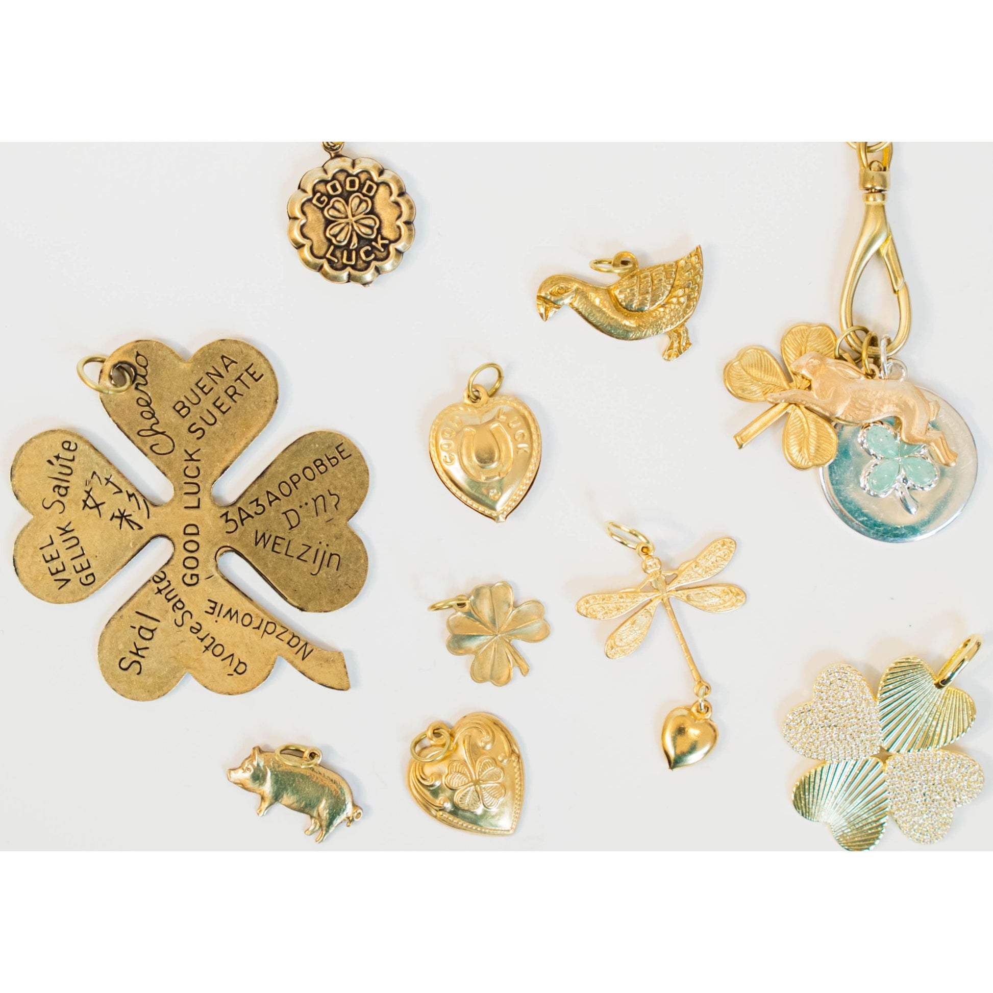 Collection of various gold st patricks day jewlery charms on a white background