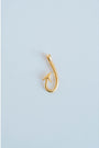 gold textured fishing hook charm on a light grey background