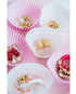 red, white, pink, and gold valentines day heart jewelry displayed in pink and white cupcake liners on a pink background